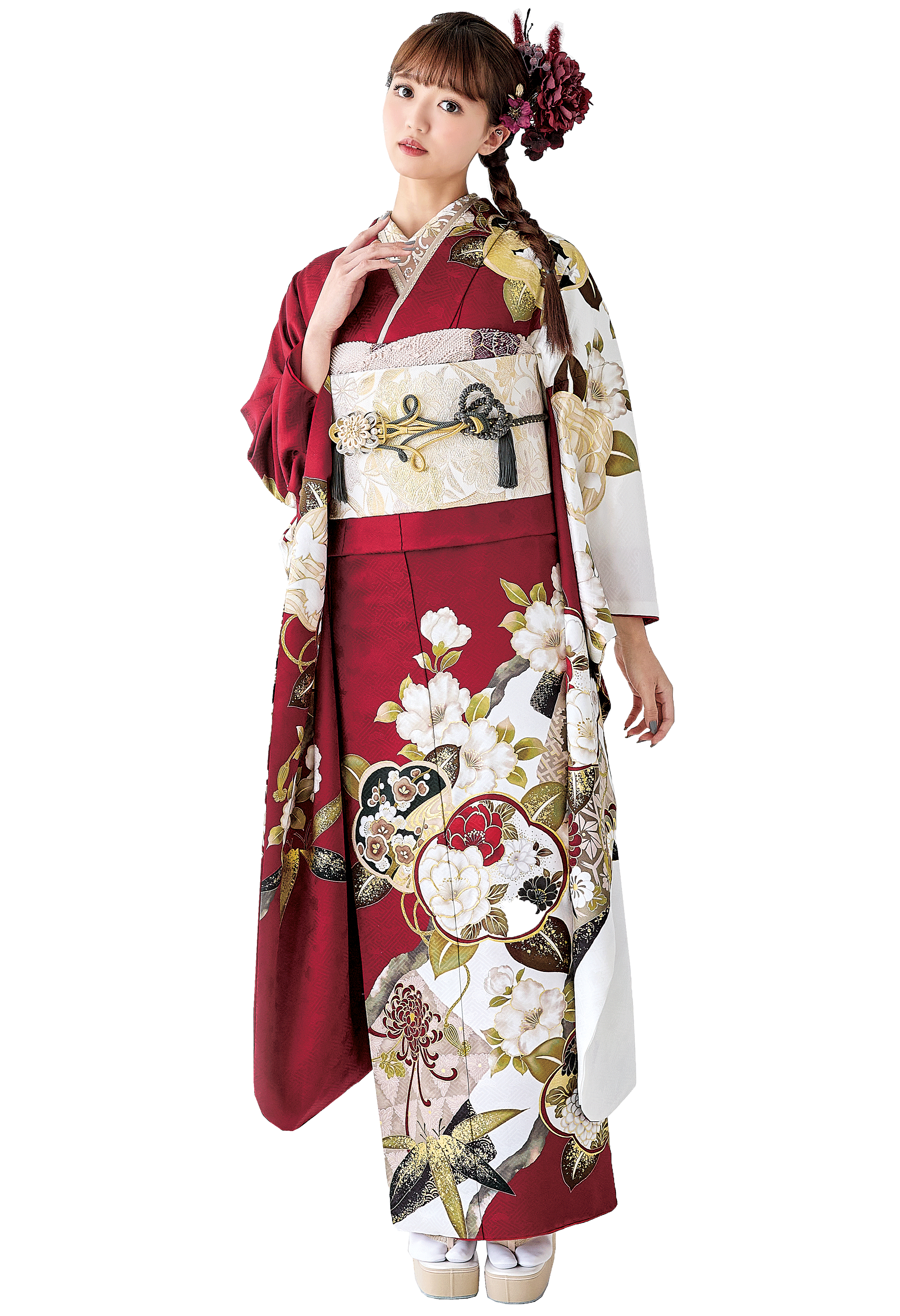 白い背景に立つ笑顔の女性。赤と白を基調とした花柄の華やかな振袖を着て、赤い髪飾りを付けている。ピンク色の和傘を持った成人式の記念写真。