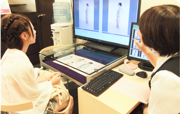 パソコンの前に座る二人の女性。共にノートパソコンやモニターを見ながら何かを確認・相談している様子。オフィスやサロンでの打ち合わせシーンが写っている。